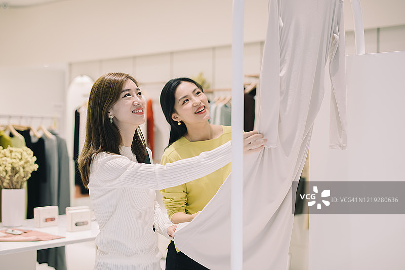 两名亚洲女性在服装店挑选新衣服图片素材