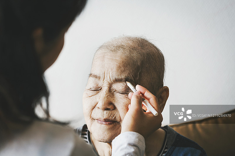 中年女儿在家为患癌老母亲化妆图片素材