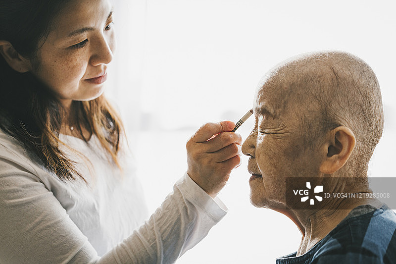 中年女儿在家为患癌老母亲化妆图片素材