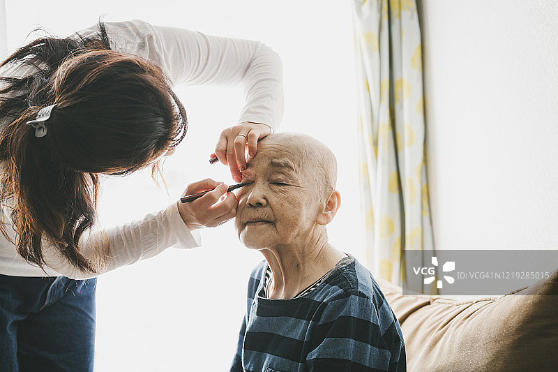 中年女儿在家为患癌老母亲化妆图片素材