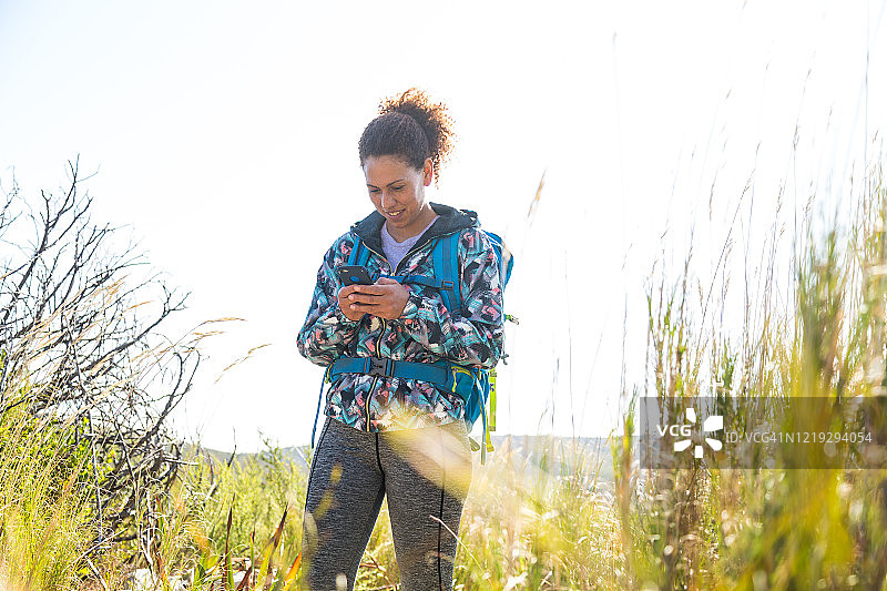 在户外徒步时看手机的女人图片素材