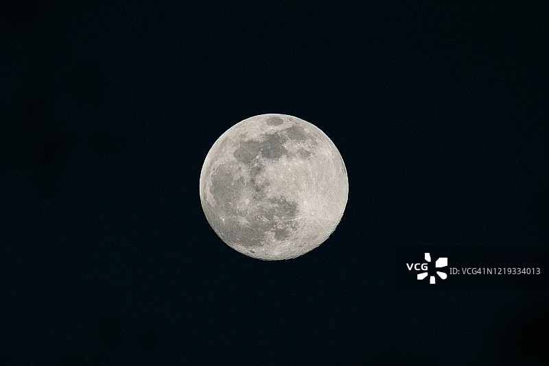 黑暗夜空中的陨石坑满月图片素材