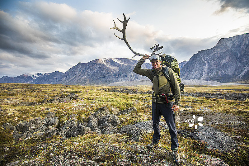 背包客在加拿大奥伊图克国家公园拿着驯鹿角图片素材