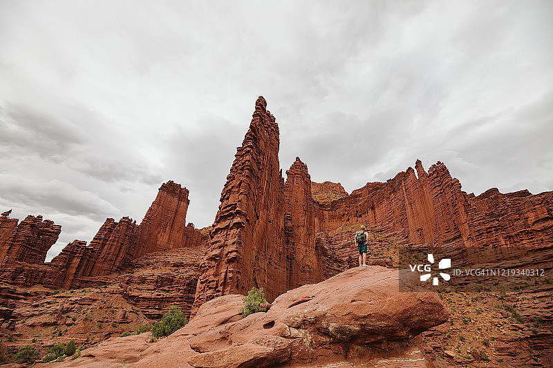 男人抬头看着犹他州摩押附近的渔夫塔图片素材
