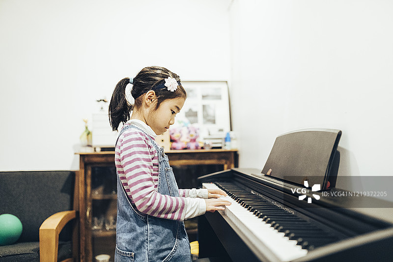 在家练习钢琴的亚洲女孩图片素材