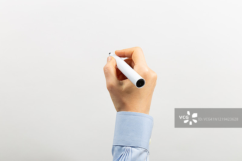 手臂在透明白板上用黑色马克笔书写图片素材