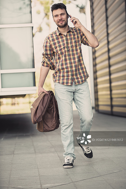 穿着休闲服打电话的现代年轻男人图片素材