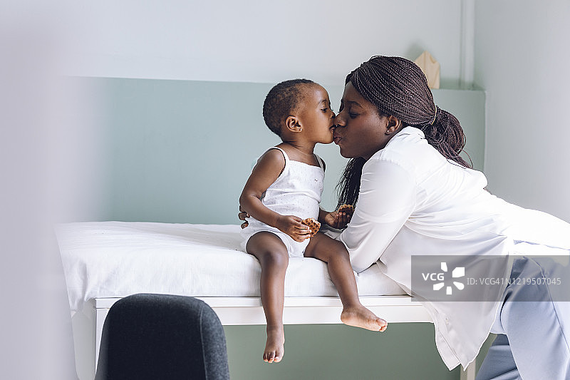 非裔美国女孩在诊所亲吻她的妈妈图片素材