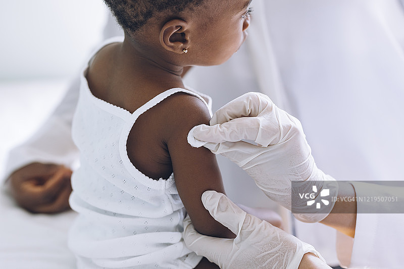 在诊所接种流感疫苗的可爱非裔美国女婴的特写图片素材