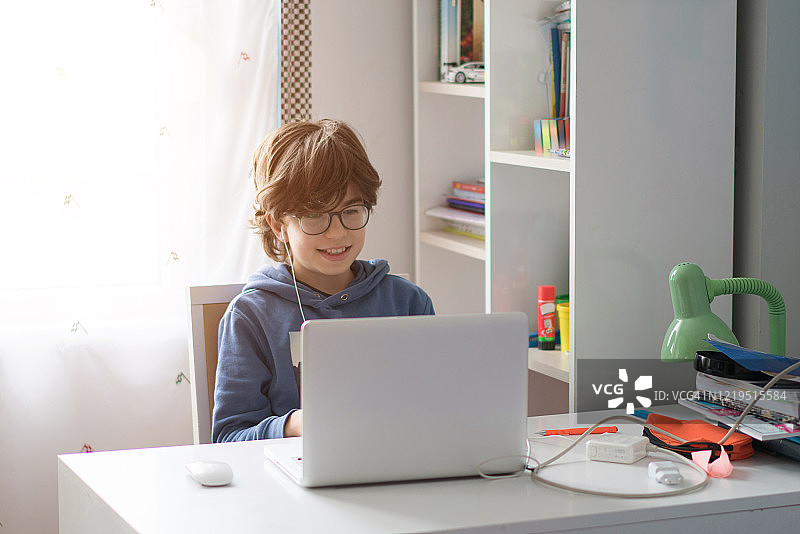 男孩在客厅里上网课图片素材