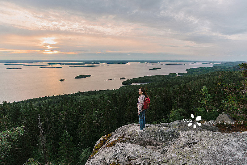 在芬兰，女人看着湖的风景图片素材