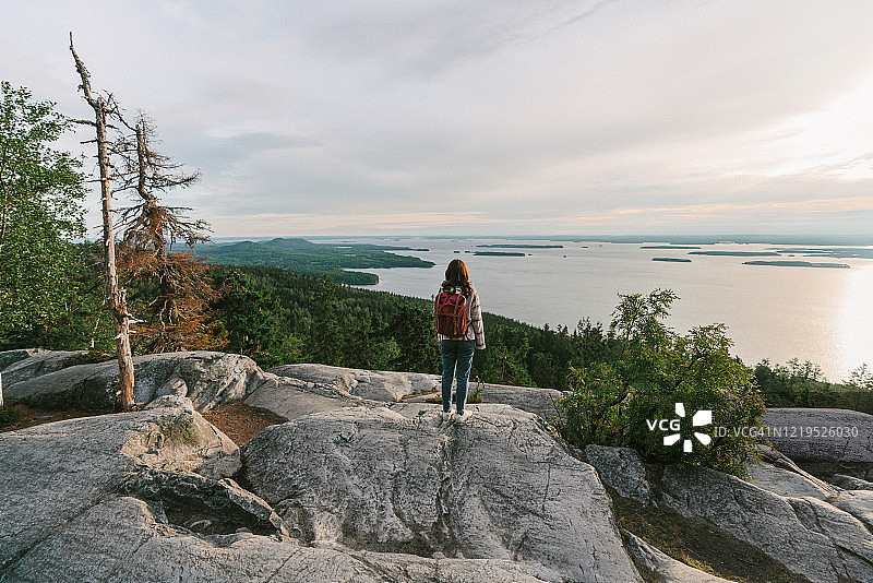 在芬兰，女人看着湖的风景图片素材