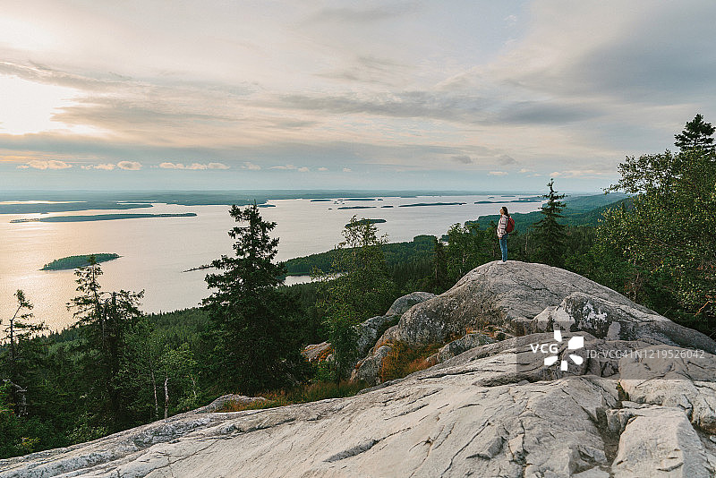 在芬兰，女人看着湖的风景图片素材