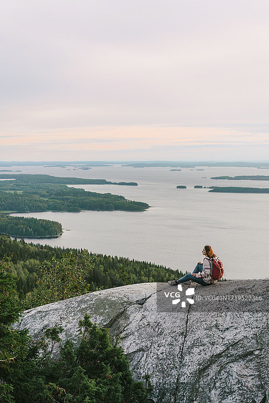 在芬兰，女人看着湖的风景图片素材