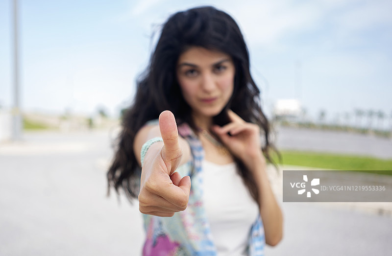 竖版：年轻漂亮女人竖起大拇指看着你图片素材