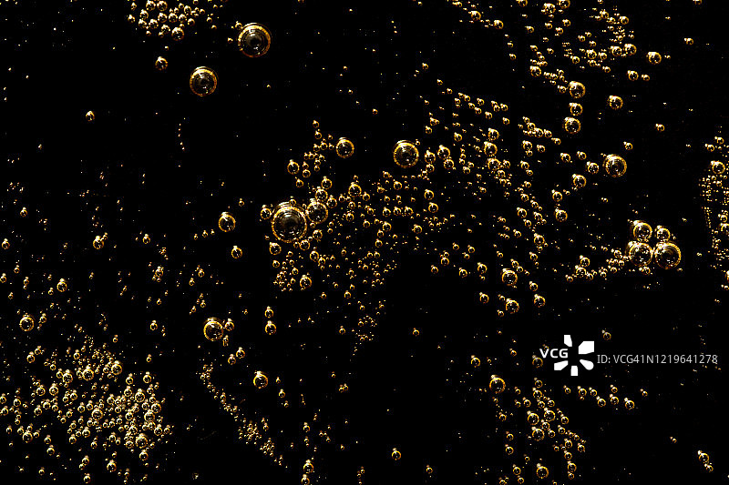 黑色背景上带气泡的透明凝胶霜化妆品，透明质酸液体凝胶，顶部视角图片素材