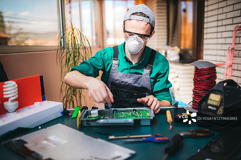 年轻电工在实验室维修电脑主板图片素材
