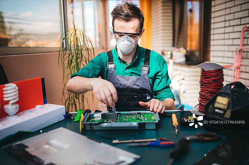 年轻电工在实验室维修电脑主板图片素材