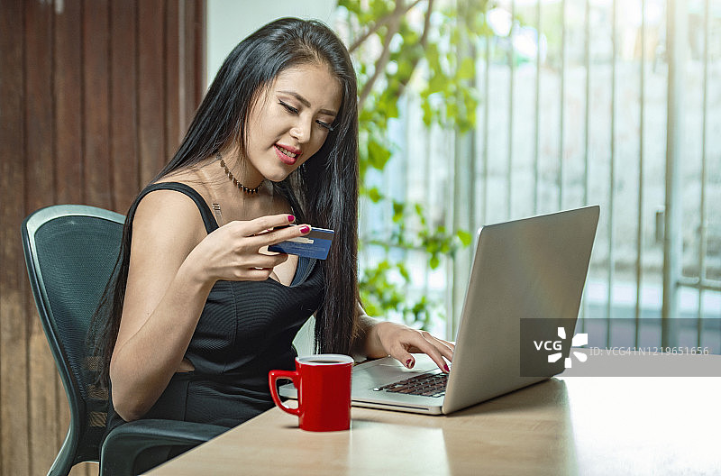 用笔记本电脑和信用卡支付的女人图片素材