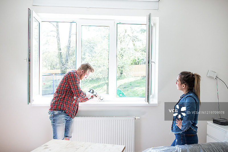 年轻夫妇正在装修他们的家。图片素材