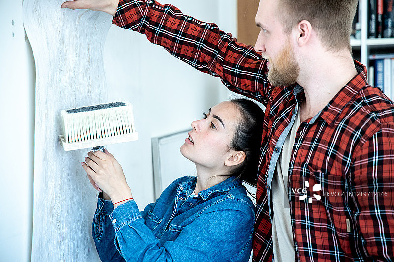 年轻夫妇正在装修他们的家。图片素材