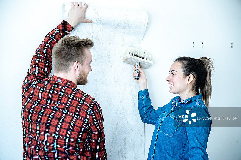 年轻夫妇正在装修他们的家。图片素材