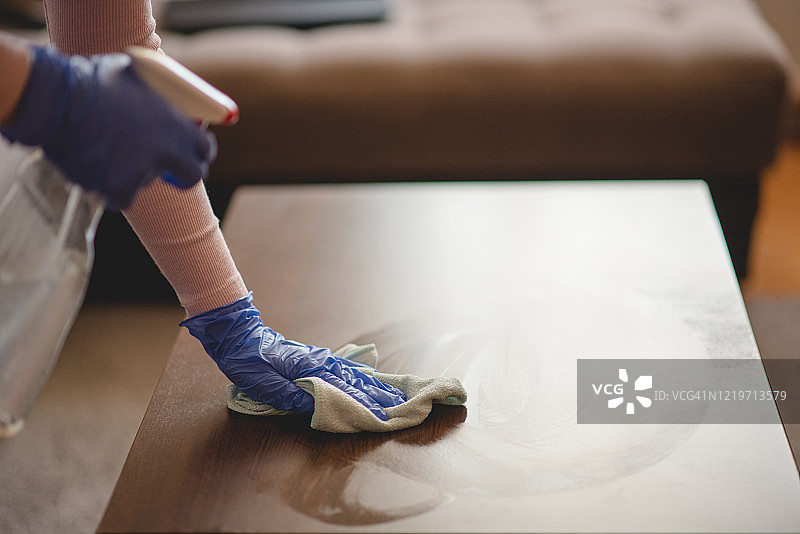 女人在客厅擦拭桌子上的灰尘图片素材