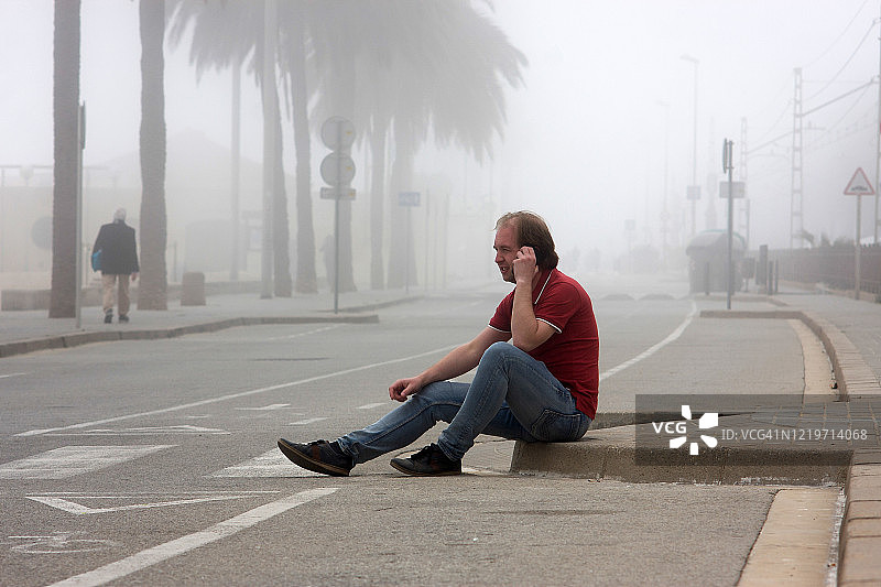空旷街道上路边孤独的中年男人图片素材