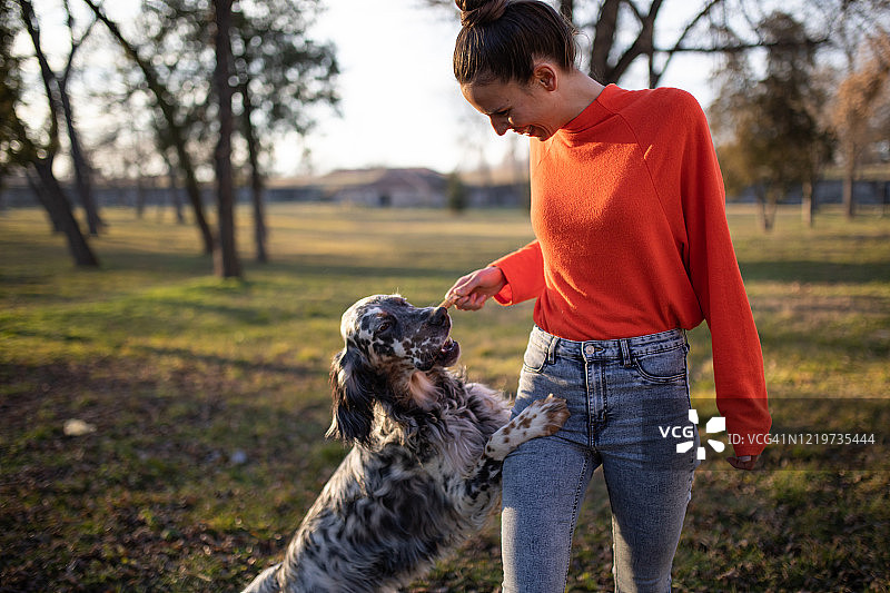 一位年轻女人和她的狗玩耍的照片图片素材