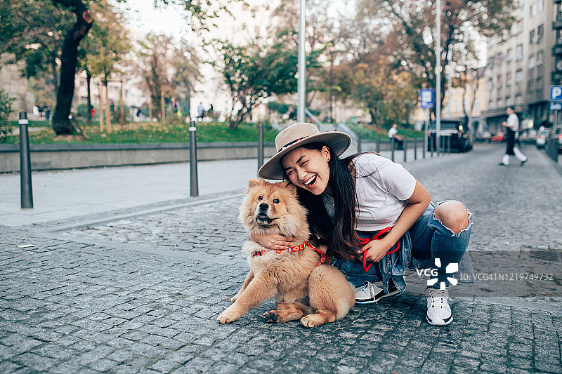 和她的狗在一起的年轻漂亮女人图片素材
