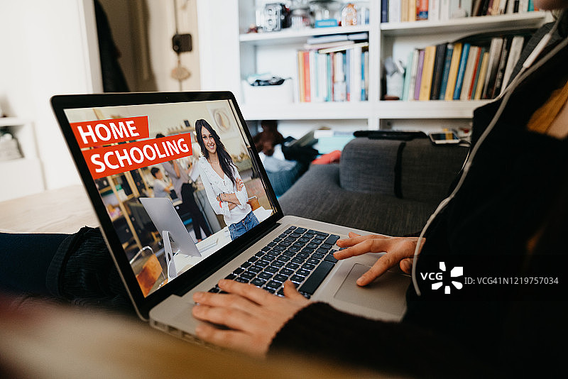 在家使用笔记本电脑观看在线课堂的年轻女人图片素材