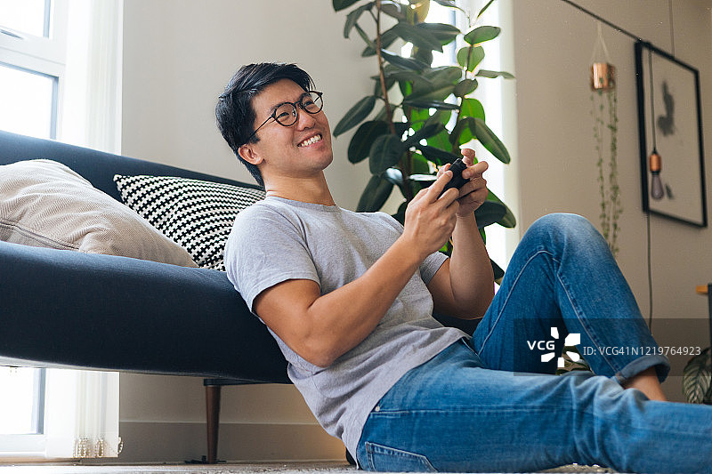 年轻男人在家玩电子游戏图片素材