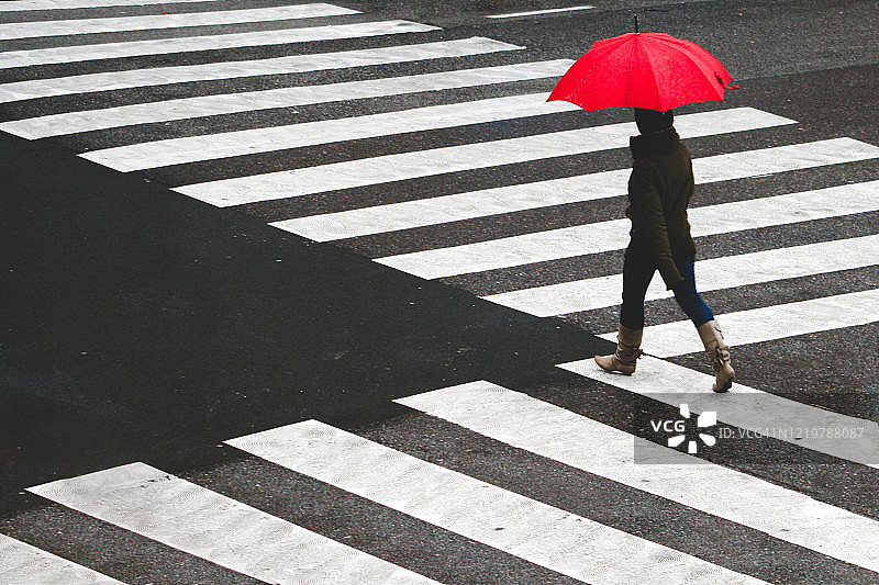 在人行横道撑伞的女人图片素材