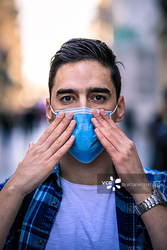 戴口罩的男人走在街上，预防病毒和流感图片素材