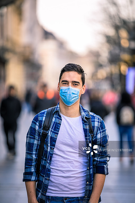 戴口罩的男人走在街上，预防病毒和流感图片素材