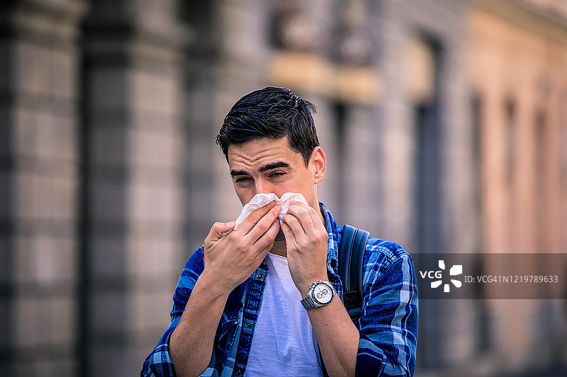 英俊的时髦男子正在擤鼻涕图片素材