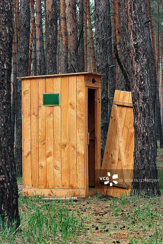 带破损门的木制户外旱厕图片素材