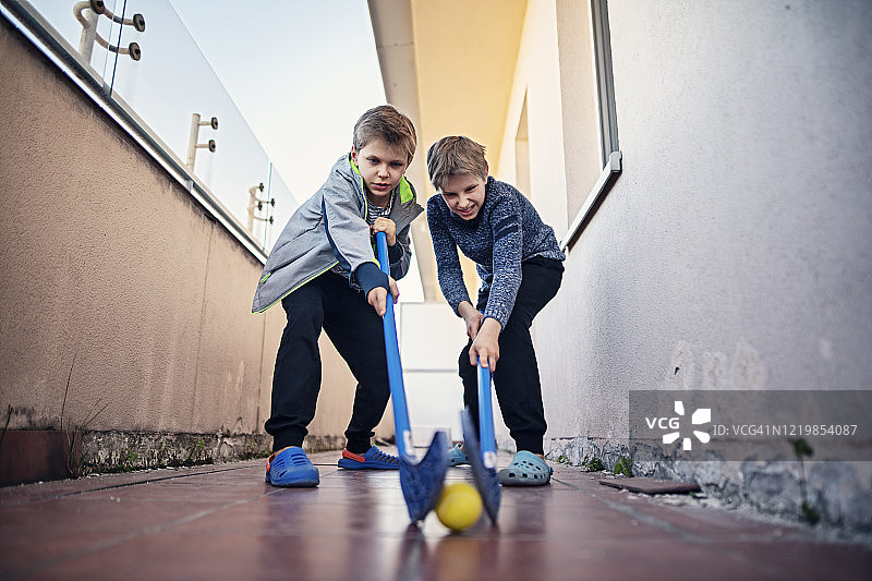 孩子们在阳台上玩临时曲棍球图片素材