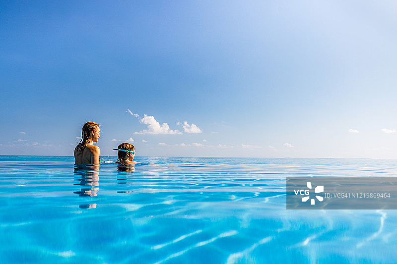 单亲妈妈和小儿子在无边泳池边看风景图片素材