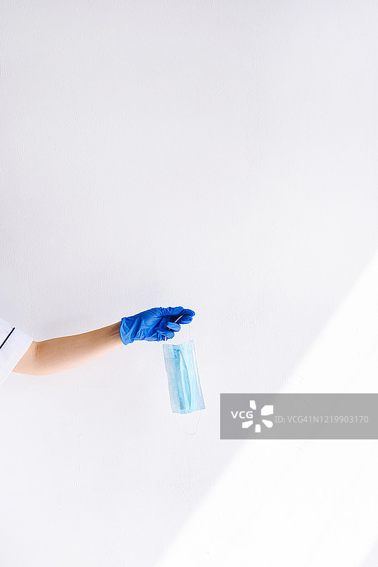 戴手套的医生手中的医用口罩图片素材