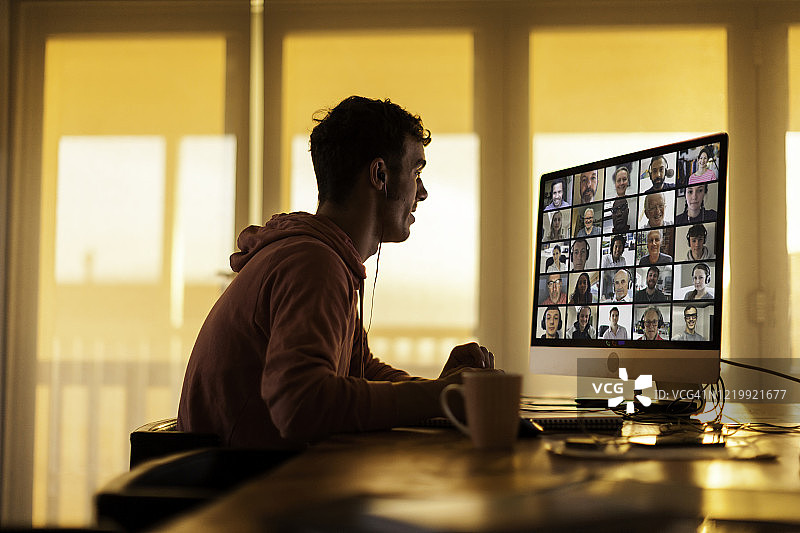 封锁期间在家中与同事进行视频通话的年轻男子图片素材