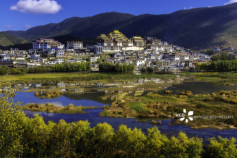 云南香格里拉松赞林寺远景及其在水中的倒影图片素材