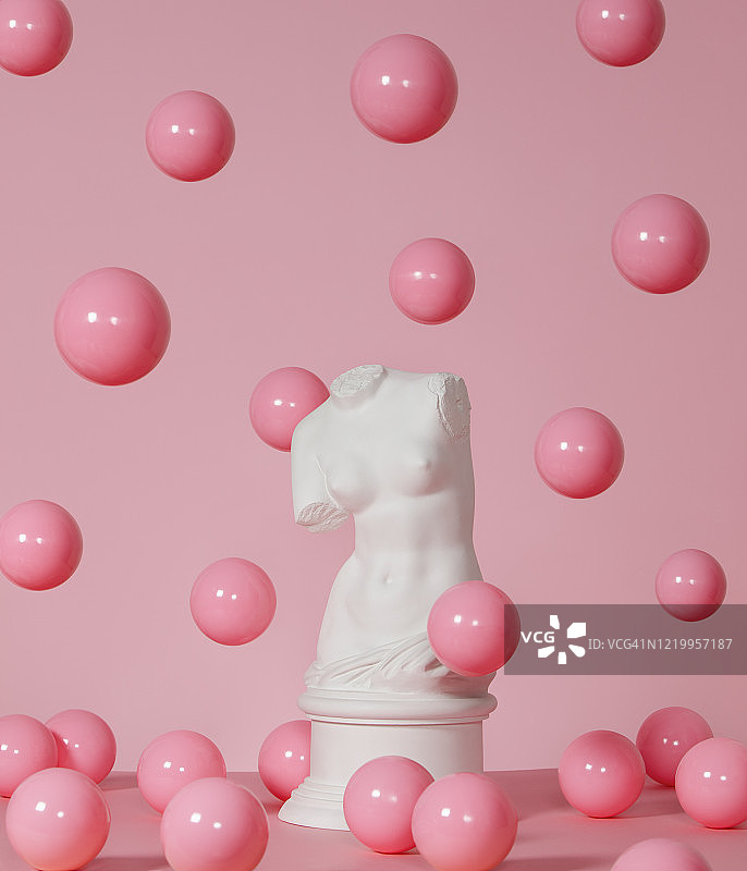 维纳斯的石膏躯干被飞舞的粉红色球体包围图片素材