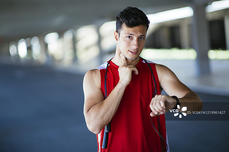 休息时检查脉搏的男运动员肖像图片素材