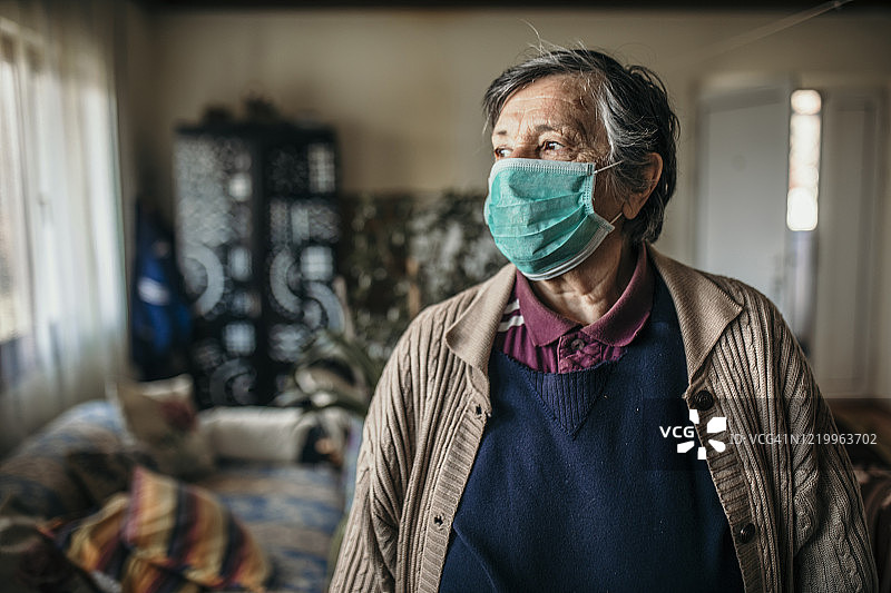 戴口罩、看向远方的年长妇女图片素材