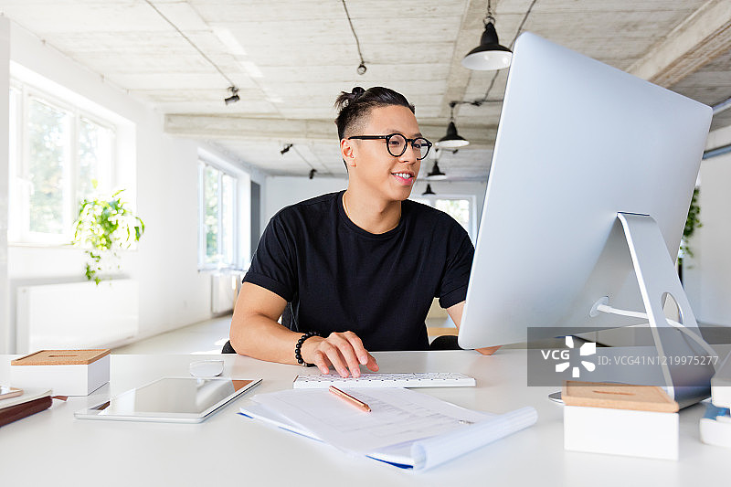 在创意工作场所工作的英俊亚洲男人图片素材