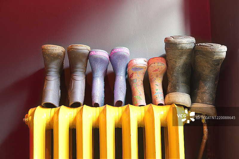 晾在暖气片上的家庭威灵顿靴图片素材