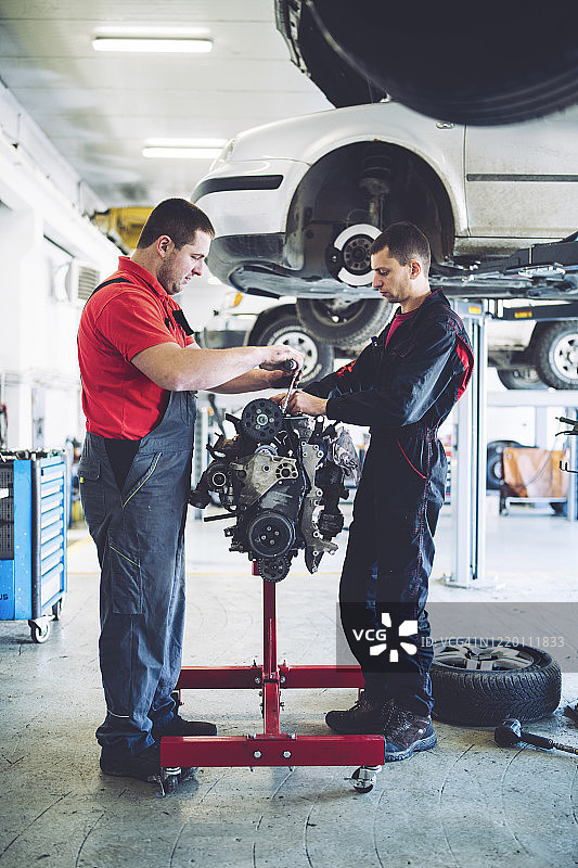 两位男机械师修理引擎全身照图片素材