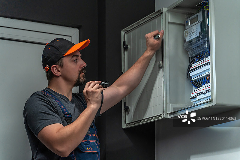 电工用手电筒修理保险丝盒图片素材