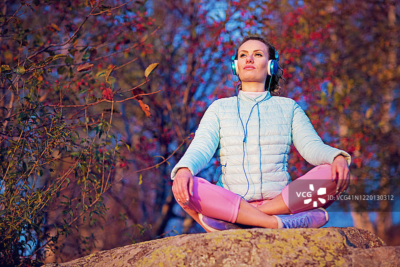 跑步后，女人在做瑜伽，听音乐放松图片素材